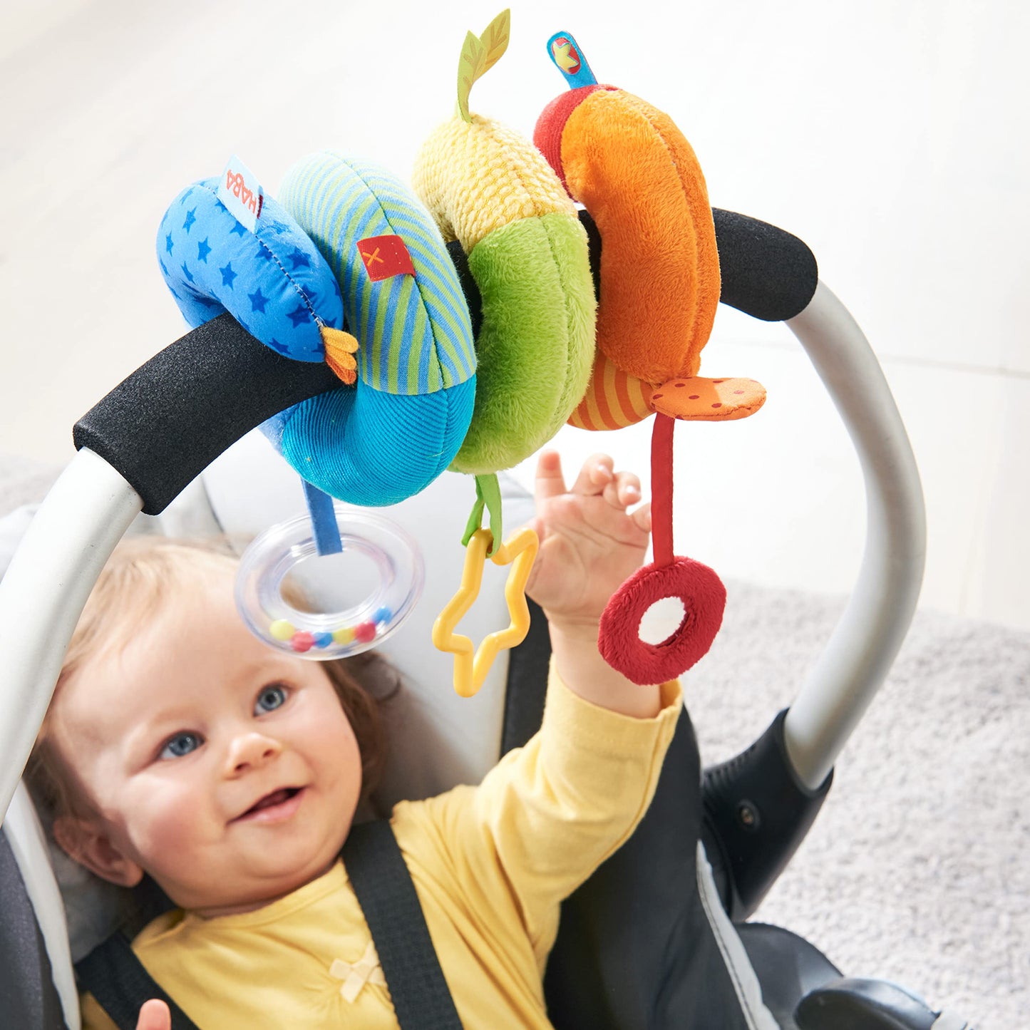 HABA Rainbow Activity Spiral Car Seat Toy and Stroller Toys for Baby 0-18 Months - Colorful Baby Travel Toy with Rattle Teething Element and Sensory Activities